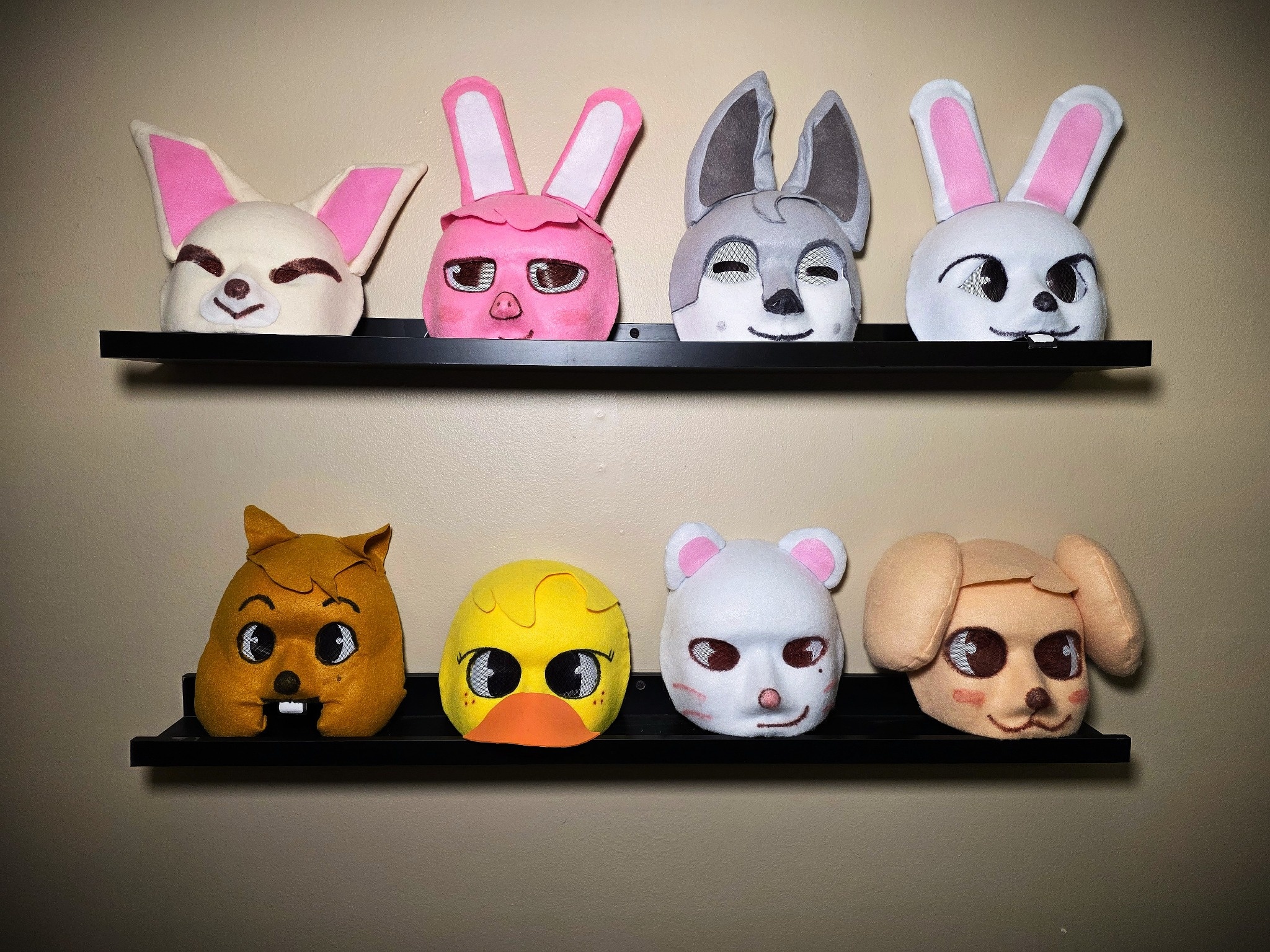 All eight handmade SKZoo masks displayed on two black shelves